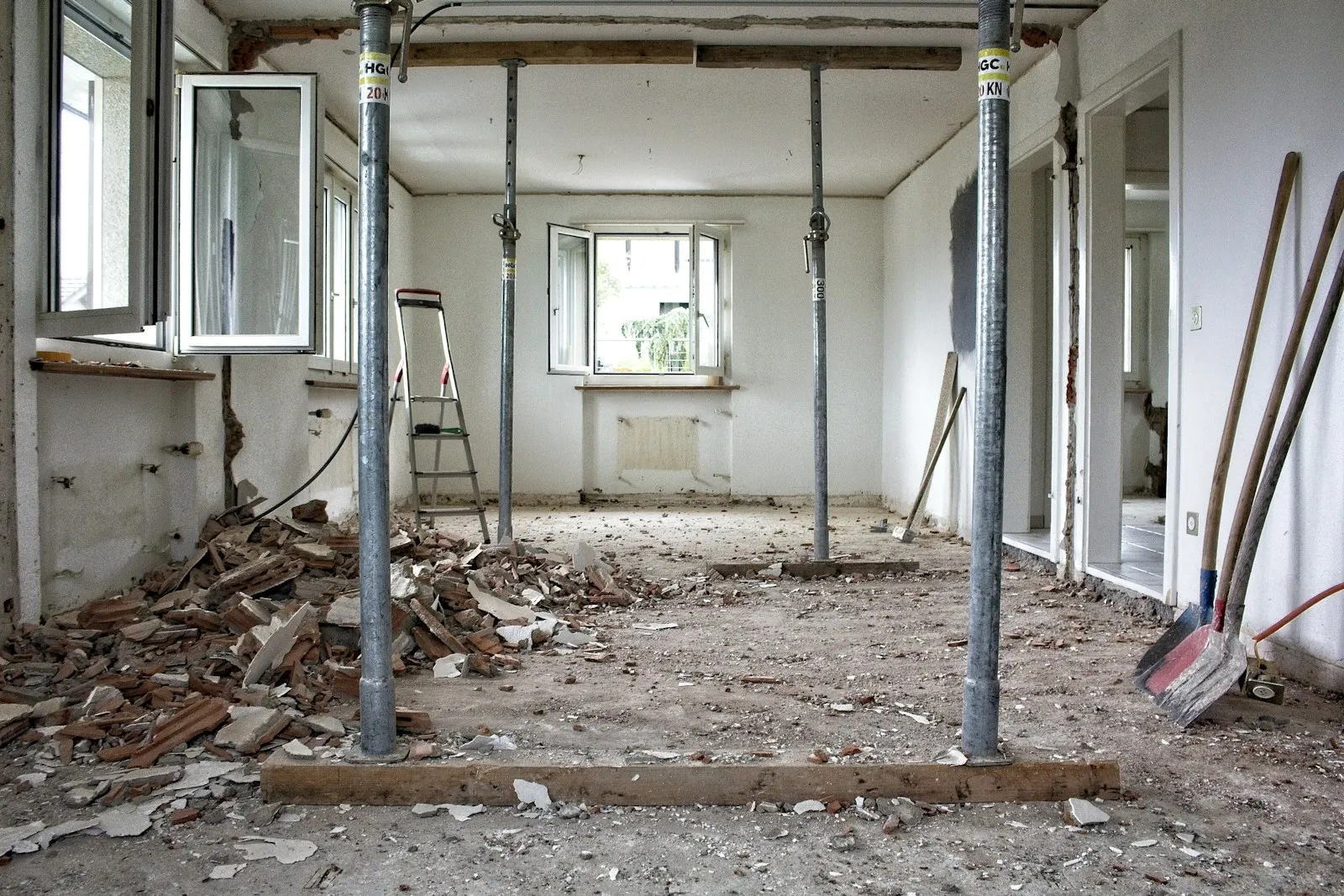 A gutted room mid renovation with temporary supports and debris on the floor